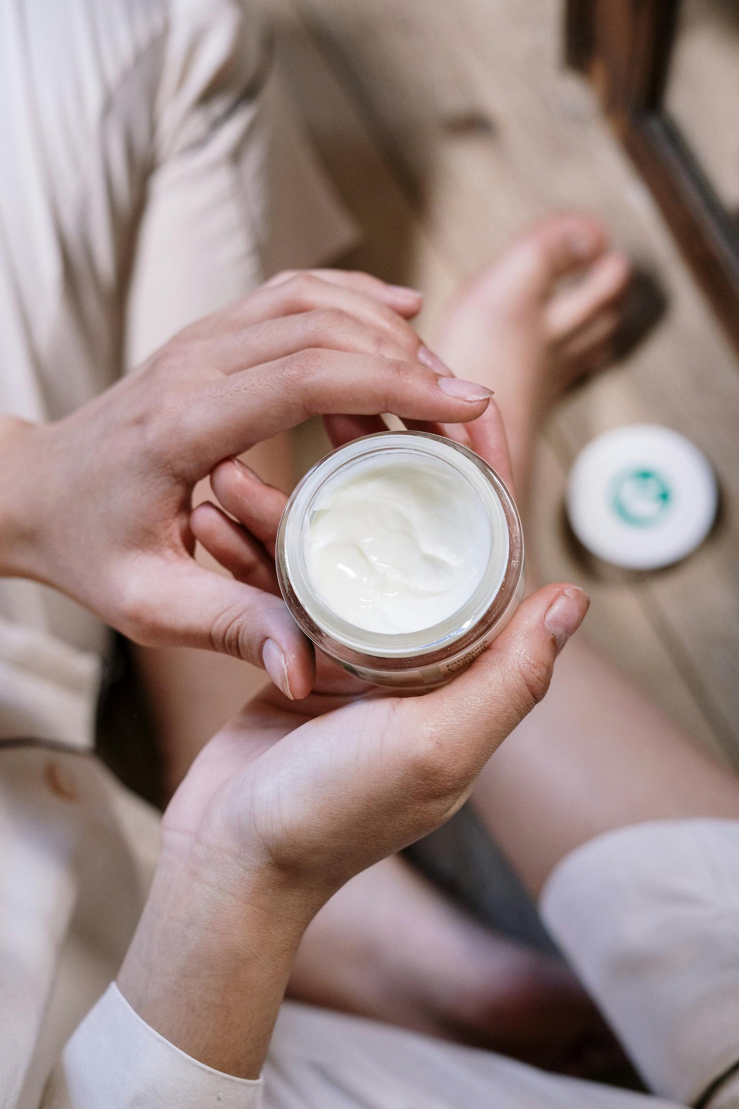 Femme assise en tailleur, tenant délicatement un pot de Crème Lift Anti-Âge Silhouette by S entre ses mains. Cette crème visage, riche en bave d’escargot, acide hyaluronique et collagène, est formulée à 99% d'ingrédients naturels pour lisser les rides, tonifier la peau et raviver l’éclat du teint. Sa texture légère pénètre rapidement sans film gras, idéale pour une routine beauté anti-âge quotidienne qui protège et régénère la peau