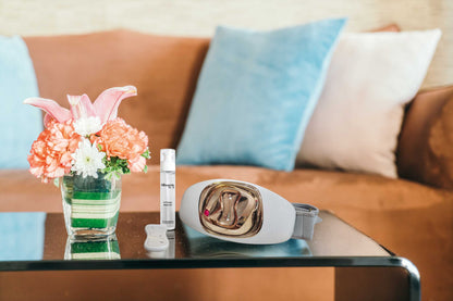 Appareil BodySvelte accompagné du gel corps Silhouette by S, posés sur une table en verre dans un salon.